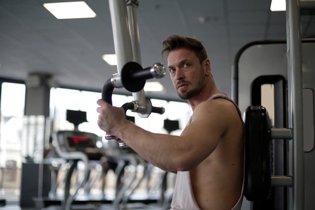 about-02 Focused man working out in a gym, showcasing biceps and determination.