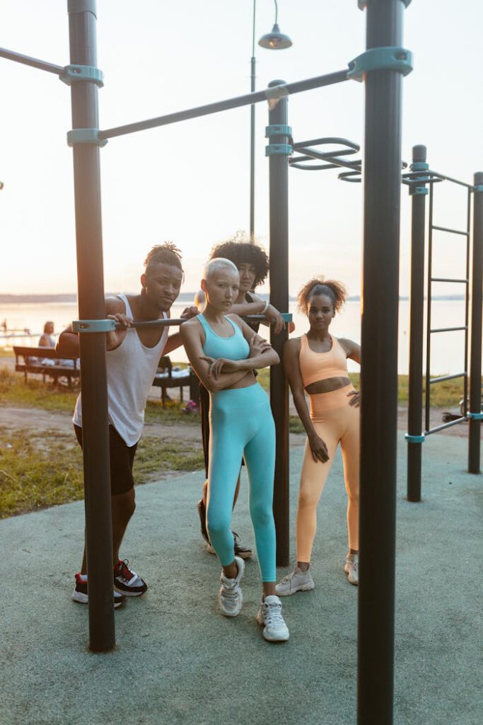 A dynamic group of friends enjoys an outdoor workout session at sunset by a scenic waterfront.