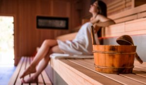 Woman relaxing in a wooden sauna.